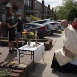 El reverendo Peter Purpura se arrodilla en un altar improvisado frente a una casa en el vecindario de Middle Village en Queens, el 17 de mayo de 2020. (James Estrin / The New York Times)

