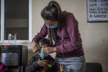 Como parte de las acciones de prevención de COVID-19, se implementó un protocolo de medición de temperatura a los niños, mujeres y hombres en el refugio un refugio de Baja California. 
(Foto: Omar Martínez  /Cuartoscuro