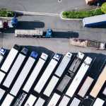 Tecnología transporte: vista superior de un aparcamiento de camiones lleno de trailers