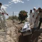 Trabajadores de un cementerio entierran a una víctima del coronavirus en una zona especial dedicada a los afectados por la enfermedad, en Ciudad Juárez, México (AP)