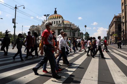 People cross a road near Zocalo Square during the gradual reopening of commercial activities in the city, as the coronavirus disease (COVID-19) outbreak continues, in Mexico City, Mexico July 13, 2020. REUTERS/Henry Romero