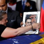 Luz Albán pone una foto sobre el ataúd de su hermano Fernando Alban durante una ceremonia en la Asamblea Nacional de Caracas (REUTERS/Marco Bello)