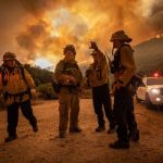 Bomberos conversan en medio de los incendios (EFE/EPA/CHRISTIAN MONTERROSA)