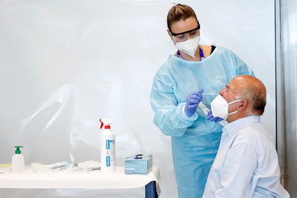 Un trabajador de la salud toma una muestra de hisopo de un hombre para analizar la enfermedad del coronavirus (COVID-19), en el aeropuerto de Fiumicino en Roma, Italia, el 23 de septiembre de 2020. (REUTERS/Remo Casilli)