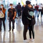 Una pareja se besa en el aeropuerto Madrid-Barajas Adolfo Suárez, junto a otros viajeros protegidos con mascarillas. EFE/Emilio Naranjo/Archivo
