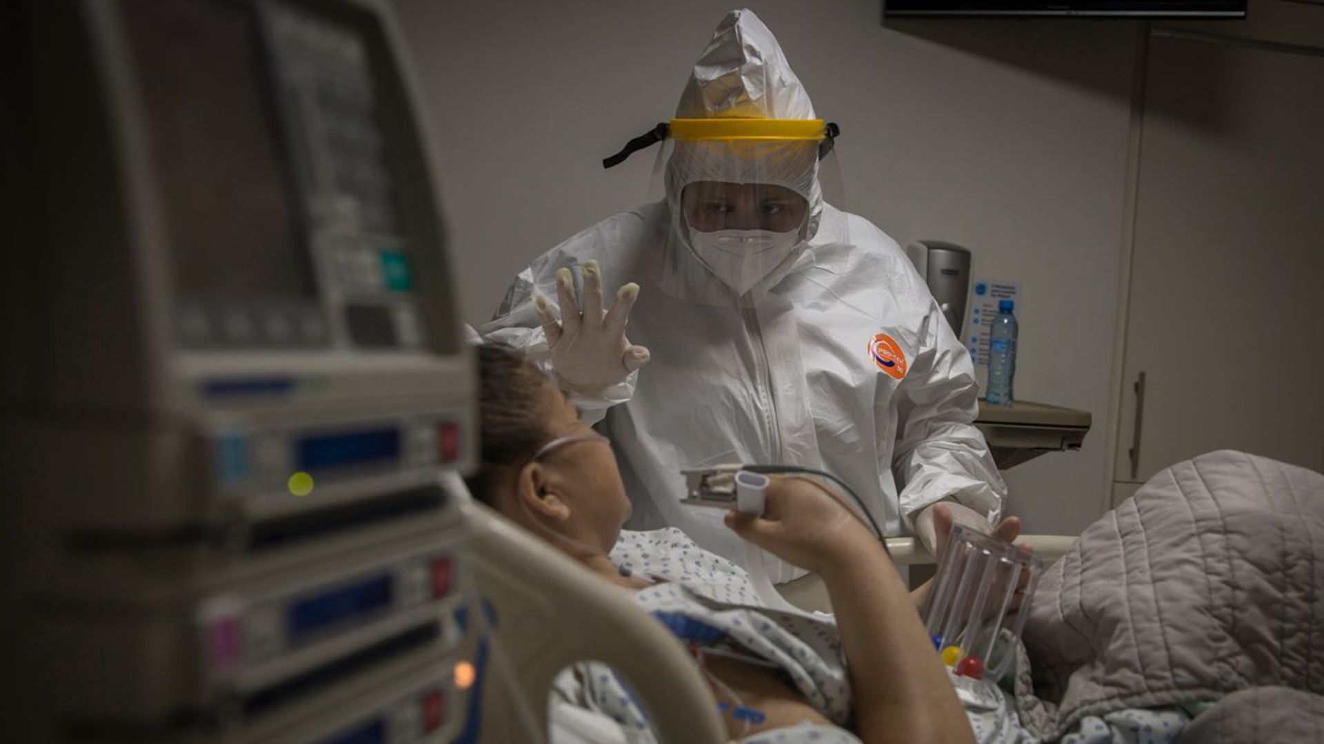 Una enfermera asignada al área Covid de la Cruz Roja, asesora a una paciente sobre la terapia que debe realizar para ejercitar sus pulmones.