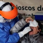 A healthcare worker wearing personal protective equipment (PPE) takes a swab sample from a man to be tested for the coronavirus disease (COVID-19) in Mexico City, Mexico November 6, 2020. REUTERS/Henry Romero