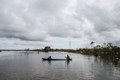 Personas navegan en botes luego de las inundaciones causadas por el huracán Iota