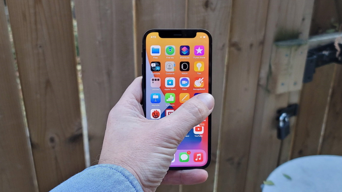 iphone 12 mini with a thumb across screen