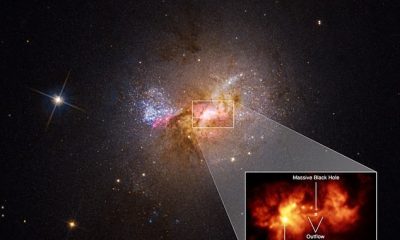 Una imagen del telescopio espacial Hubble muestra la galaxia Henize 2-10, con un agujero negro supermasivo oculto en su centro.  Una extracción de la región central de la galaxia enana con estallido estelar Henize 2-10 traza un flujo de salida, o puente de gas caliente de 230 años luz de largo, que conecta el agujero negro masivo de la galaxia y una región de formación estelar.