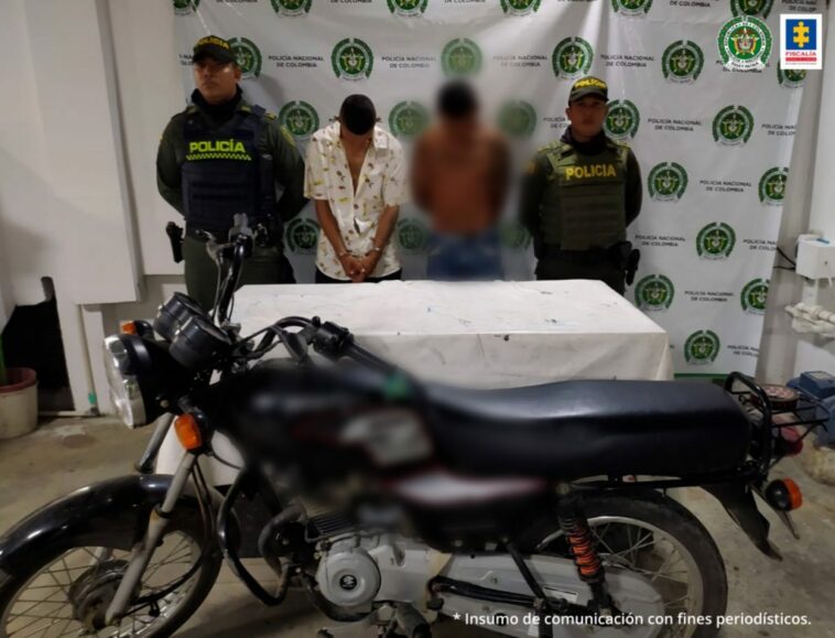 En la imagen se ven dos personas capturadas entre uniformados de la Policía y frente a una motocicleta.