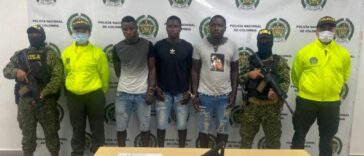 En la fotografía se observan siete personas tres de ellos los capturados, dos integrantes de Gaula Militar y dos integrantes de la Policía Nacional. En la parte posterior se observa un backing de la Policía Nacional.