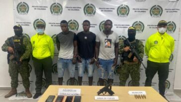 En la fotografía se observan siete personas tres de ellos los capturados, dos integrantes de Gaula Militar y dos integrantes de la Policía Nacional. En la parte posterior se observa un backing de la Policía Nacional.