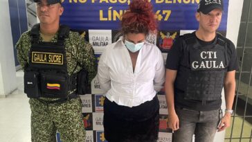 En la imagen aparece una mujer detenida entre un uniformado de la Armada y otro de la Fiscalía.