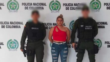 En la imagen se ve una mujer capturada entre dos policías.
