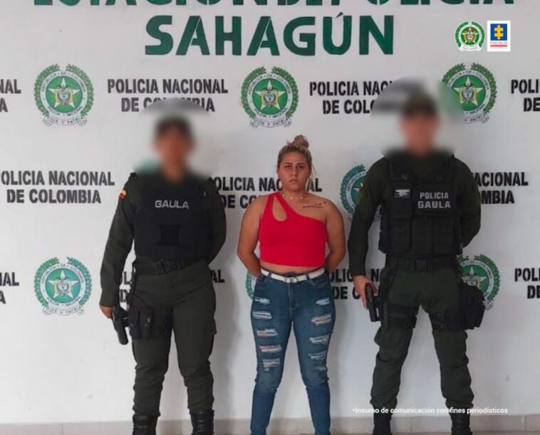 En la imagen se ve una mujer capturada entre dos policías.