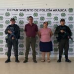 En la fotografía se aprecia a la pareja de esposos junto dos uniformados del Gaula de la Policía Nacional. En la parte posterior se observa el banner que identifica al Departamento de Policía de Arauca.